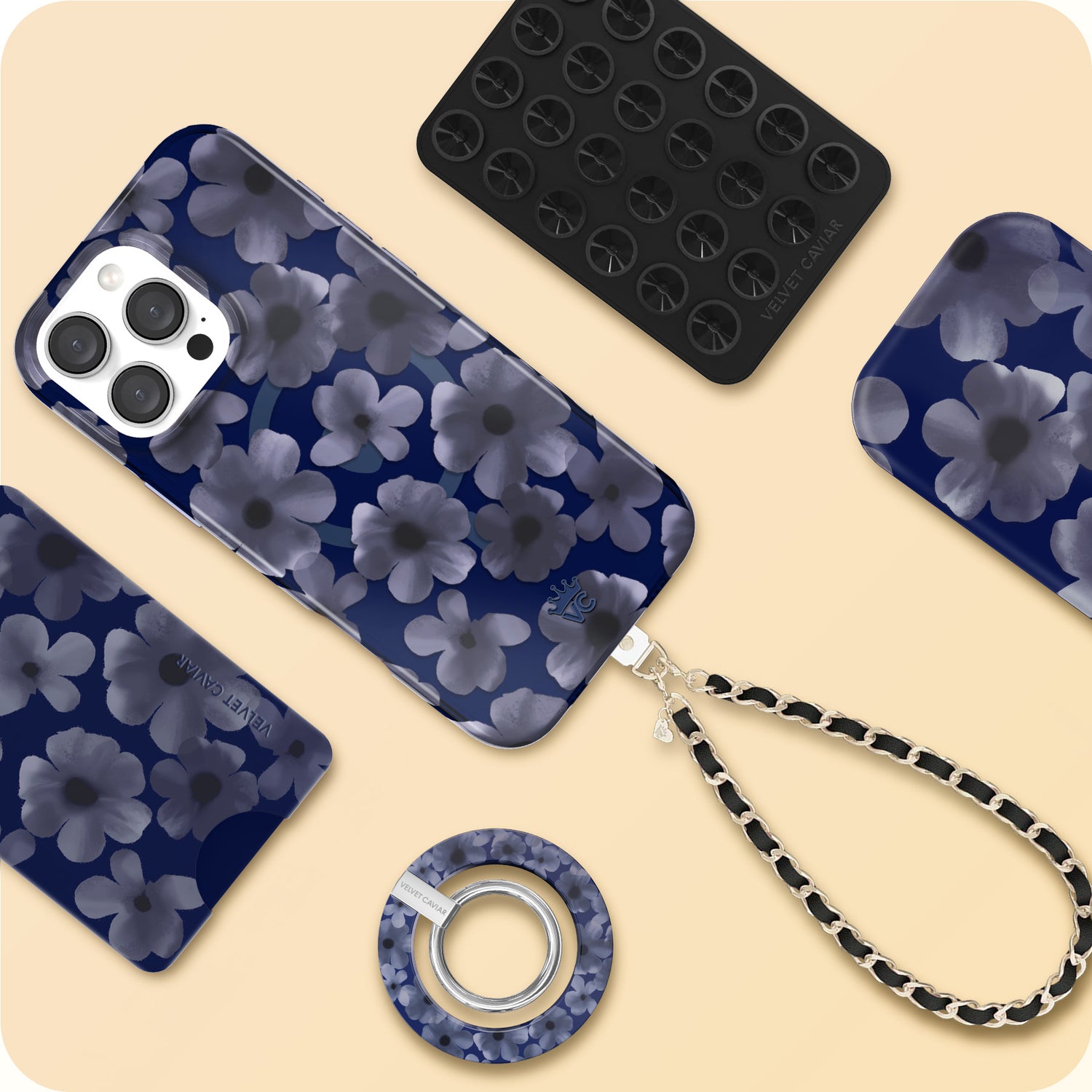 Blue floral phone case collection with matching MagSafe accessories including wireless charger, grip ring, and chain strap on beige background